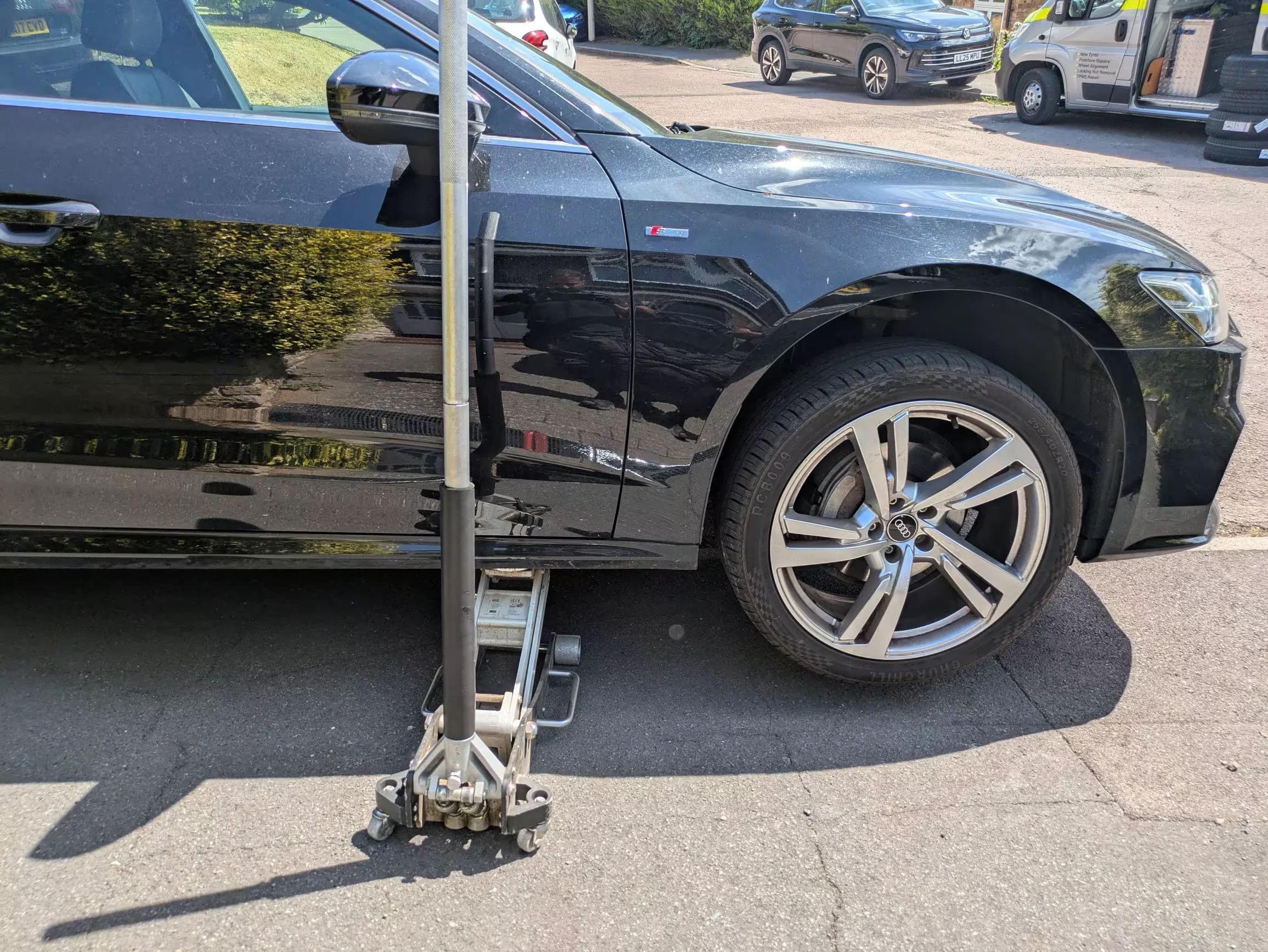 Mobile Tyre Champions technician performing emergency roadside tyre replacement at night for a stranded vehicle